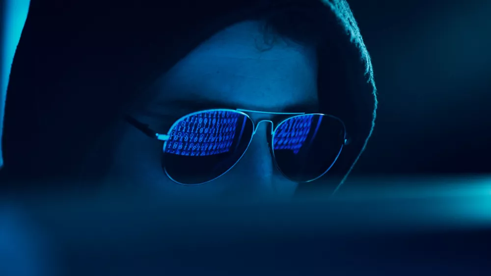 Reflection in spectacles of virus hacking a computer 1