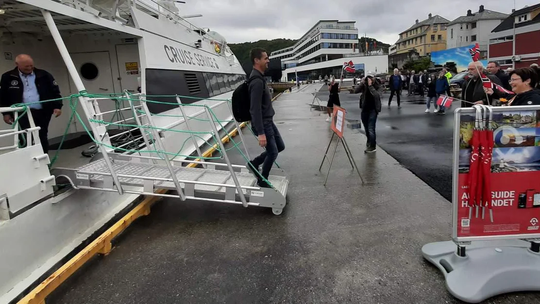 Helsa med flagg og ros fraa foerste passasjeren
